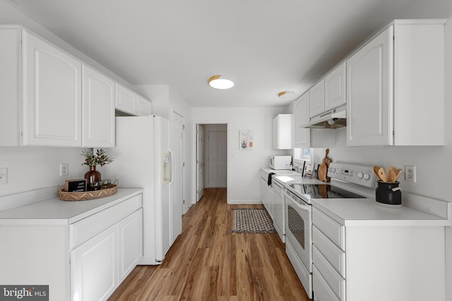 kitchen featuring white cabinets, light wood-type flooring, and white appliances