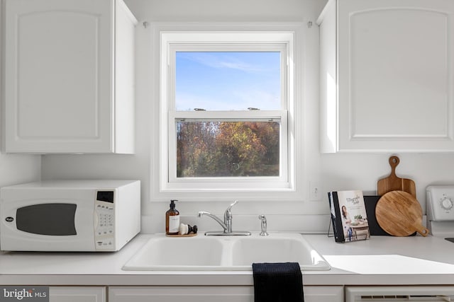 kitchen featuring white cabinets, dishwasher, and sink