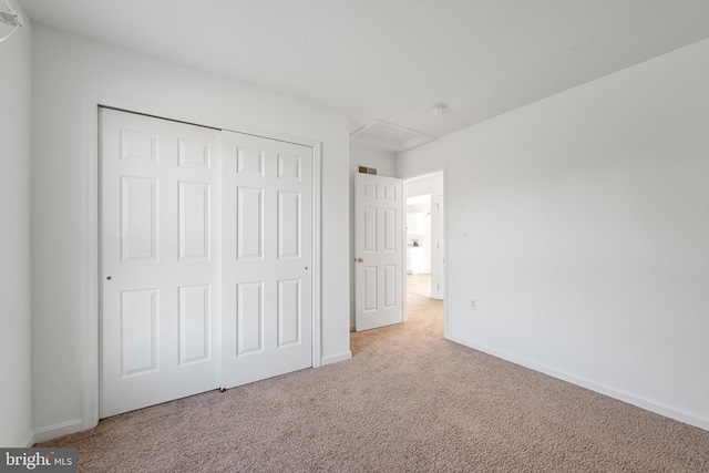 unfurnished bedroom with light carpet and a closet