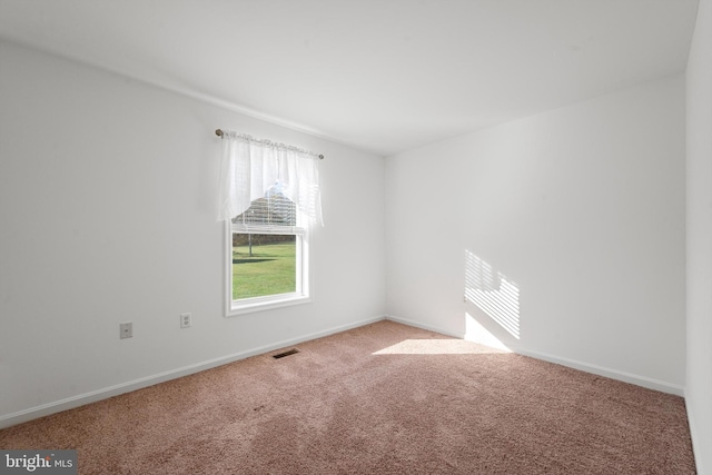 spare room featuring light colored carpet