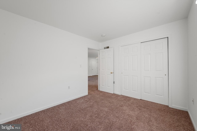 unfurnished bedroom featuring carpet floors and a closet