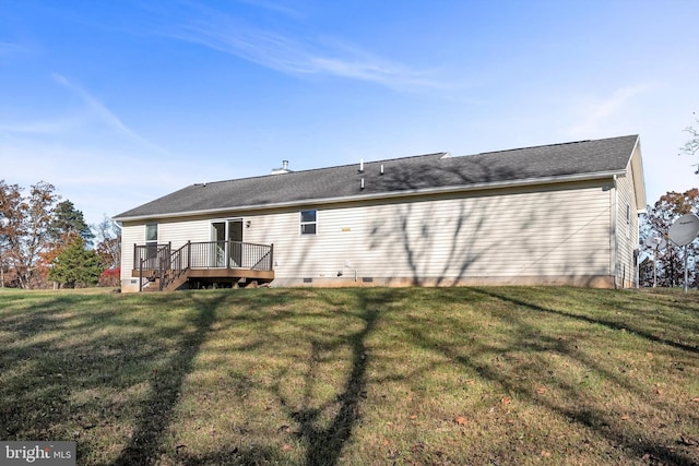 rear view of house with a lawn and a wooden deck