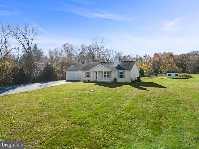 view of front of house with a front lawn, covered porch, and a garage