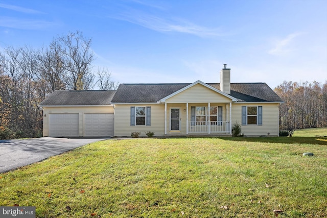 single story home featuring covered porch, a garage, and a front yard