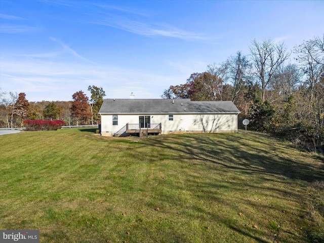 back of house with a wooden deck and a lawn