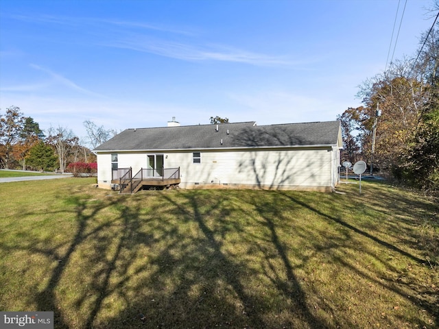 back of property with a lawn and a deck