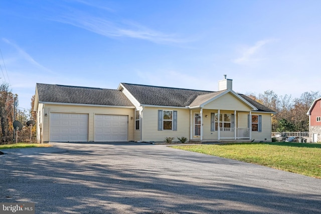 single story home featuring covered porch, a front yard, and a garage