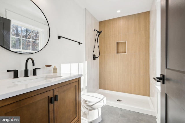 bathroom with vanity, tile patterned flooring, toilet, and a tile shower