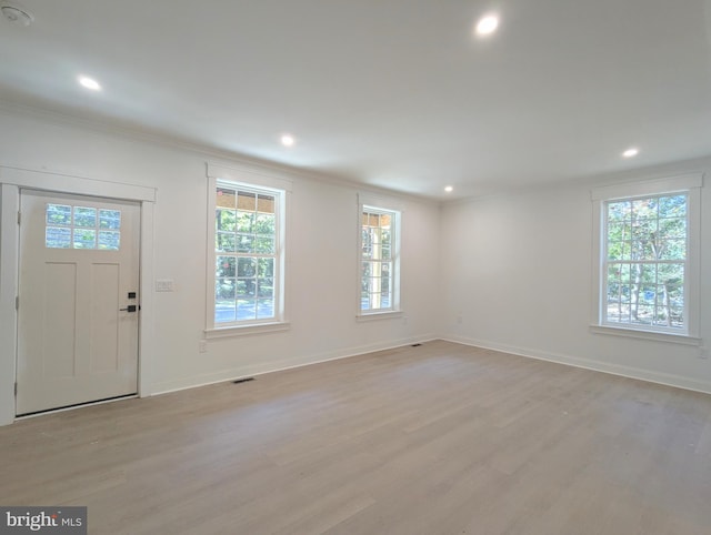 foyer with crown molding and light hardwood / wood-style flooring