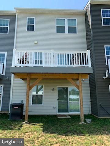 rear view of house with central AC unit and a balcony