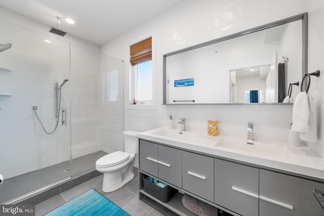 bathroom with tiled shower, tile patterned floors, vanity, and toilet