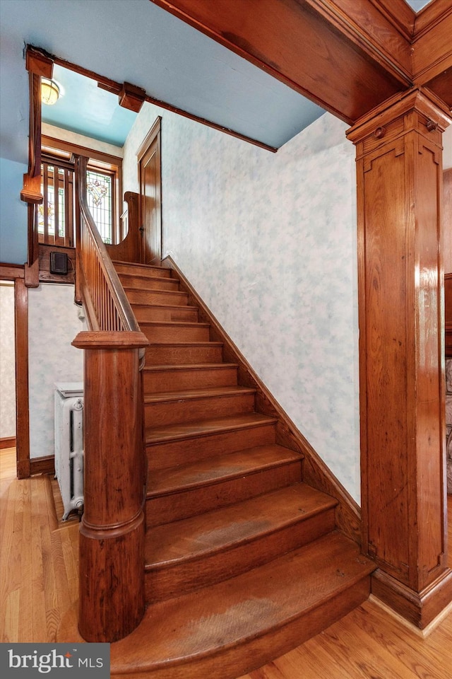 stairway featuring hardwood / wood-style flooring and wallpapered walls