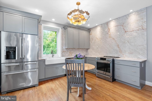 kitchen featuring a sink, light countertops, gray cabinetry, and stainless steel appliances