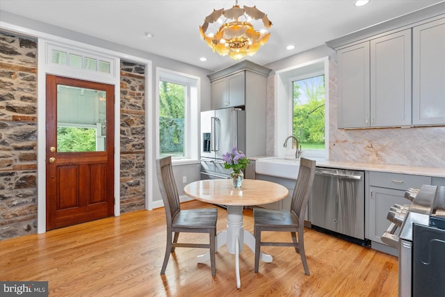 kitchen featuring light countertops, appliances with stainless steel finishes, gray cabinetry, and light wood-style floors