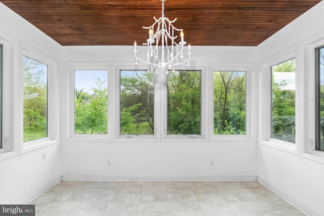 unfurnished sunroom with a chandelier, wooden ceiling, and a healthy amount of sunlight