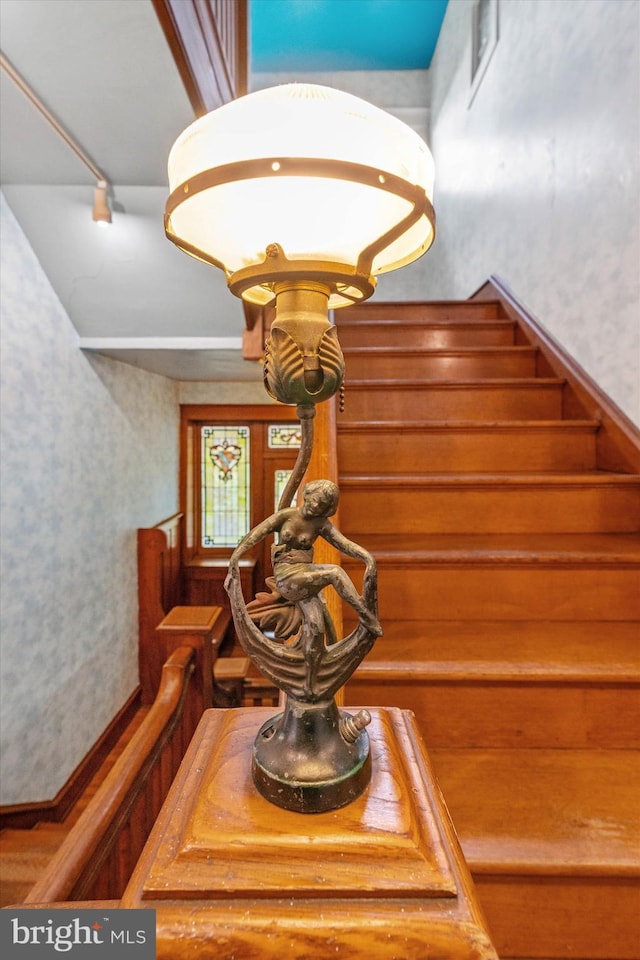 staircase with wallpapered walls and visible vents