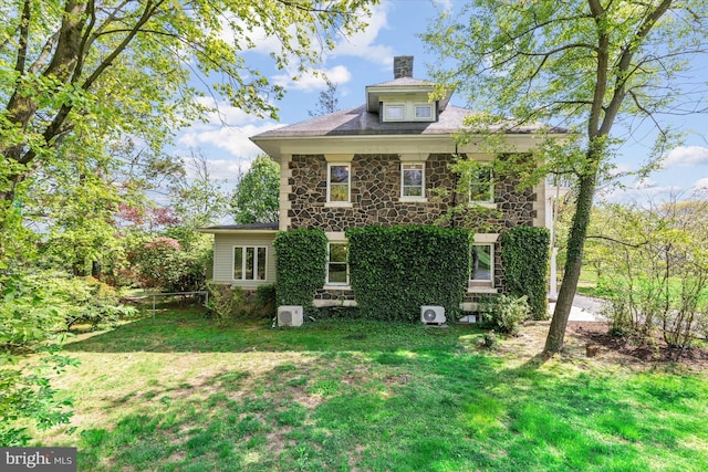 view of property exterior featuring stone siding, a chimney, and a lawn