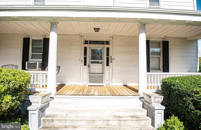 property entrance with covered porch and cooling unit