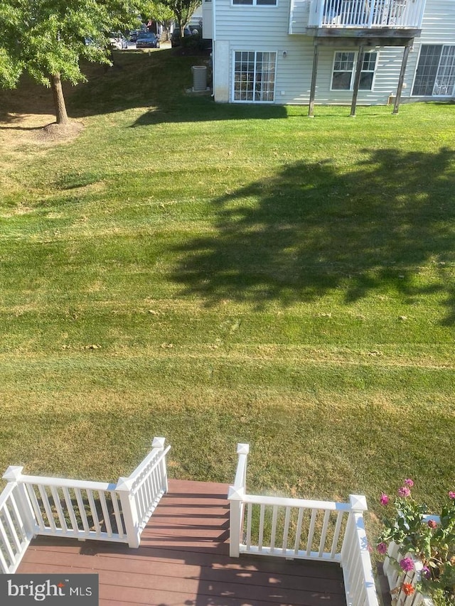 view of yard featuring central AC and a deck