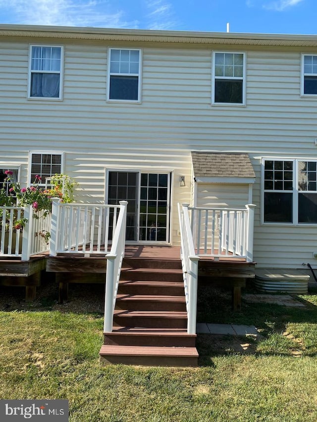 rear view of house with a yard and a wooden deck