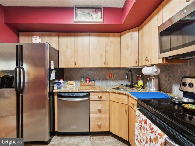 kitchen with decorative backsplash, appliances with stainless steel finishes, light brown cabinets, and sink