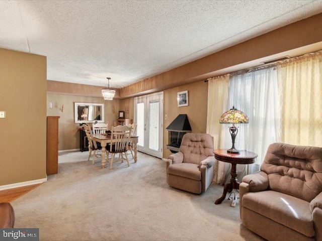 carpeted living room with french doors, a chandelier, and a textured ceiling