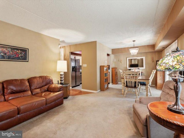 carpeted living room with a notable chandelier and a textured ceiling