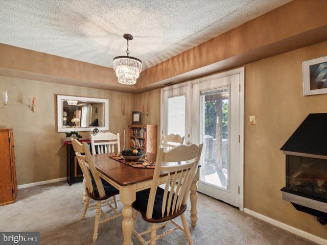 carpeted dining area with an inviting chandelier, a textured ceiling, and french doors