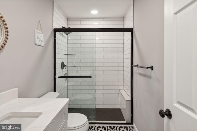 bathroom featuring vanity, toilet, and a shower with door