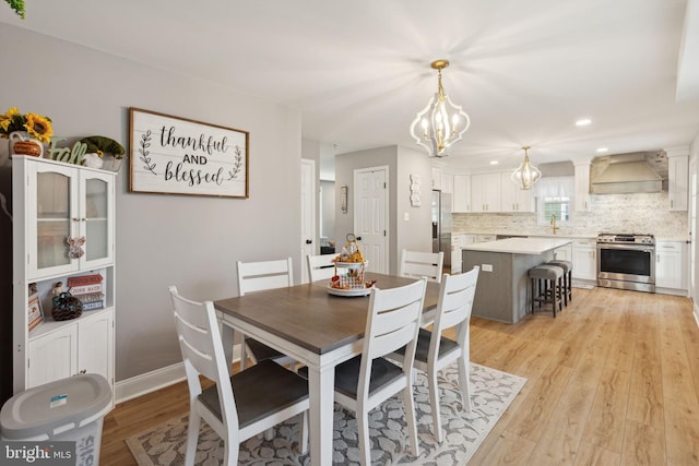 dining room with a chandelier and light hardwood / wood-style flooring