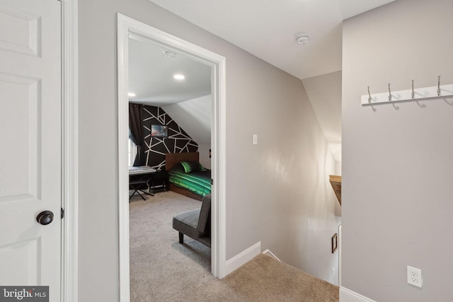 corridor featuring light carpet and vaulted ceiling