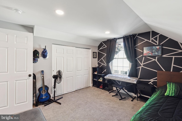 bedroom featuring lofted ceiling, a closet, and carpet