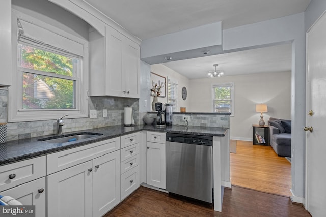 kitchen featuring stainless steel dishwasher, a sink, backsplash, dark wood-style floors, and white cabinetry