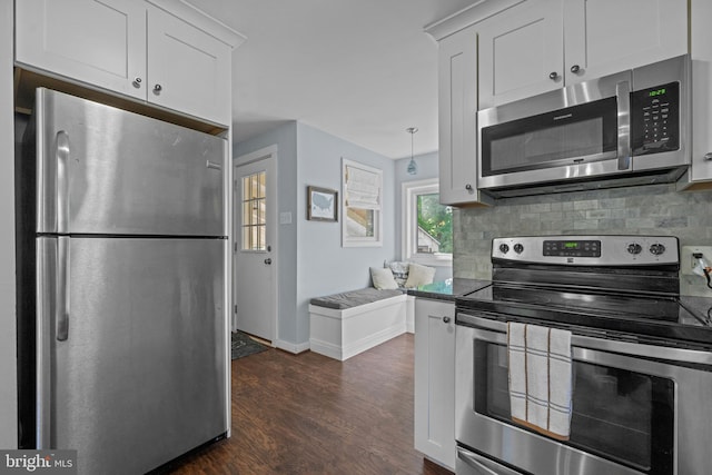 kitchen featuring stainless steel appliances, dark wood finished floors, tasteful backsplash, and white cabinetry