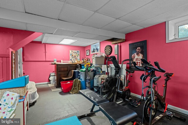 workout area featuring baseboards and a paneled ceiling
