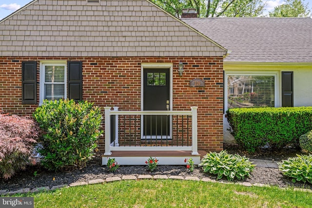 entrance to property with brick siding and a chimney