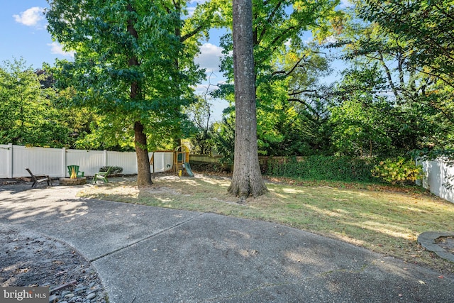 fenced backyard featuring a playground