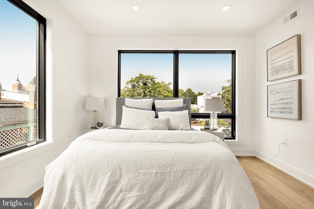 bedroom featuring light hardwood / wood-style floors and multiple windows