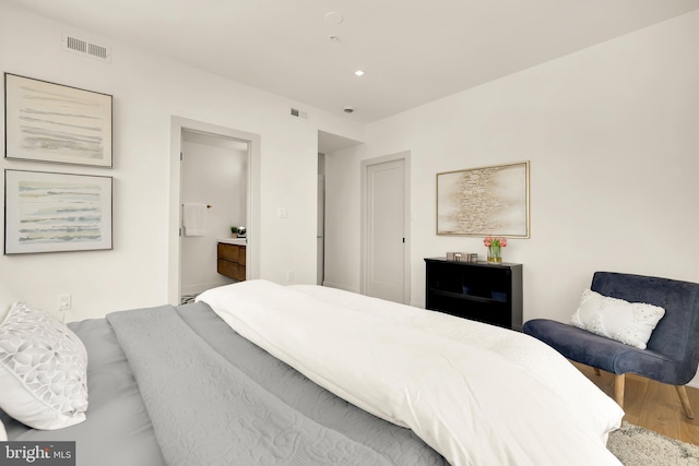 bedroom featuring hardwood / wood-style floors and ensuite bathroom