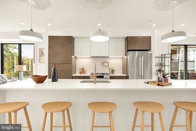 kitchen with white cabinetry, appliances with stainless steel finishes, plenty of natural light, and hanging light fixtures