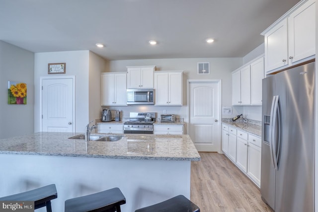 kitchen with white cabinetry, appliances with stainless steel finishes, sink, and light wood-type flooring