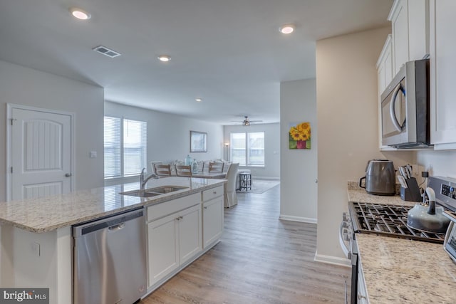 kitchen featuring appliances with stainless steel finishes, white cabinets, sink, and a wealth of natural light