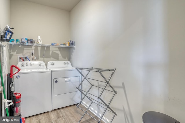 laundry area with washer and dryer and light hardwood / wood-style flooring