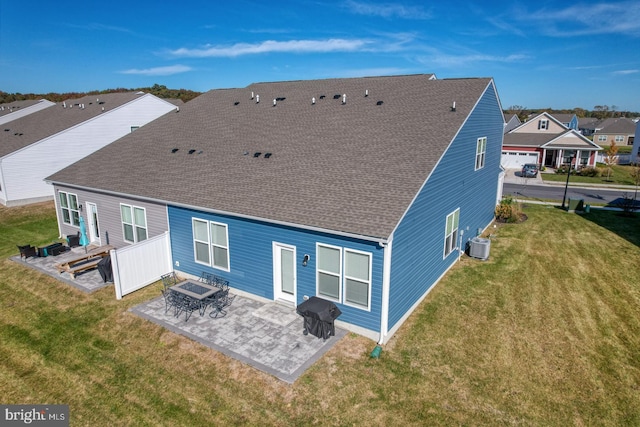 rear view of property featuring a patio, central AC unit, an outdoor fire pit, and a lawn