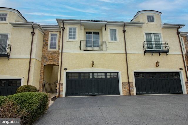 townhome / multi-family property with a balcony and a garage