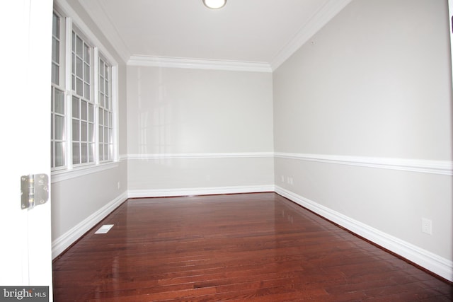 empty room featuring dark wood-type flooring and crown molding