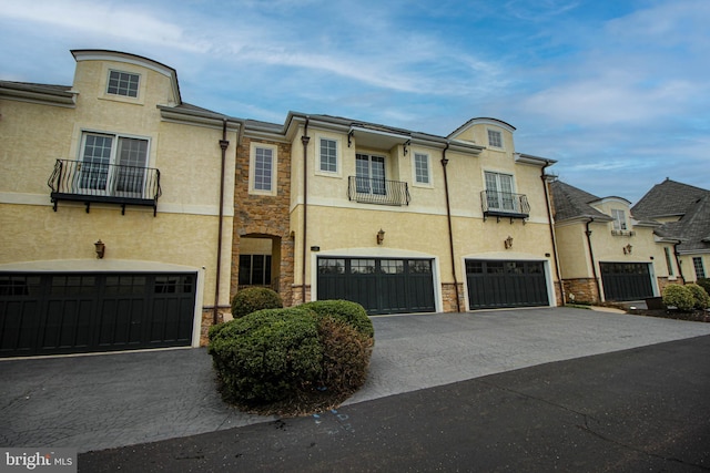 view of property with a garage and a balcony