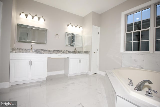 bathroom featuring vanity and tiled tub