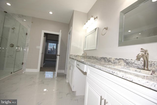 bathroom featuring a shower with door and vanity