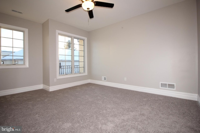 carpeted empty room with a wealth of natural light and ceiling fan